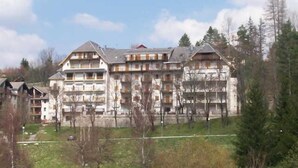 Un hotel de varios pisos con arquitectura tradicional, que cuenta con balcones y un patio central.