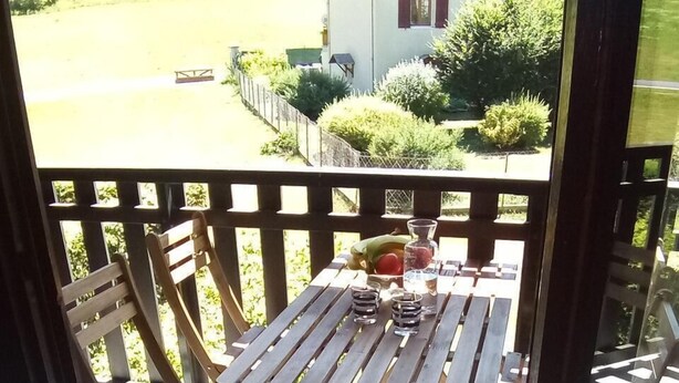 A wooden deck with a table and chairs, a glass of water, and a banana.