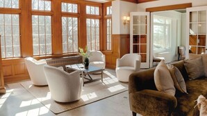 A spacious living room with large windows, a fireplace, and a cozy seating area. - Edgemoor Estate - 11 Bed/6.5 Bath (Sleeps 32) - Heated Pool Jacuzzi Beach (Gloucester)
