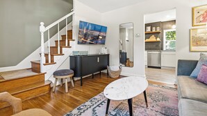 Ein modernes Wohnzimmer mit Treppe, Essbereich und Küche.
