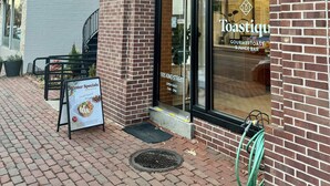 Ein Backsteinhaus mit einem Schild für 'Gourmet Toast & Juice Bar' und einem Schild mit 'Winter Specials'.