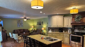 A kitchen with a central island, wooden cabinets, and stainless steel appliances. - Family friendly 12 bed, Serene small town Louisa. Cozy with wifi, AC & farm life (Louisa)