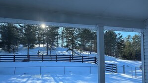 A covered outdoor area with a view of a snow-covered landscape and a wooden fence. - Family friendly 12 bed, Serene small town Louisa. Cozy with wifi, AC & farm life (Louisa)