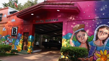 Un edificio con un mural colorido y el letrero 'HOTEL BERAKA' sobre la entrada.