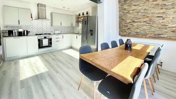 A modern kitchen with white cabinets, a herringbone backsplash, and a built-in oven. - Hereford House – Sleeps 8! BS2 (Bristol)