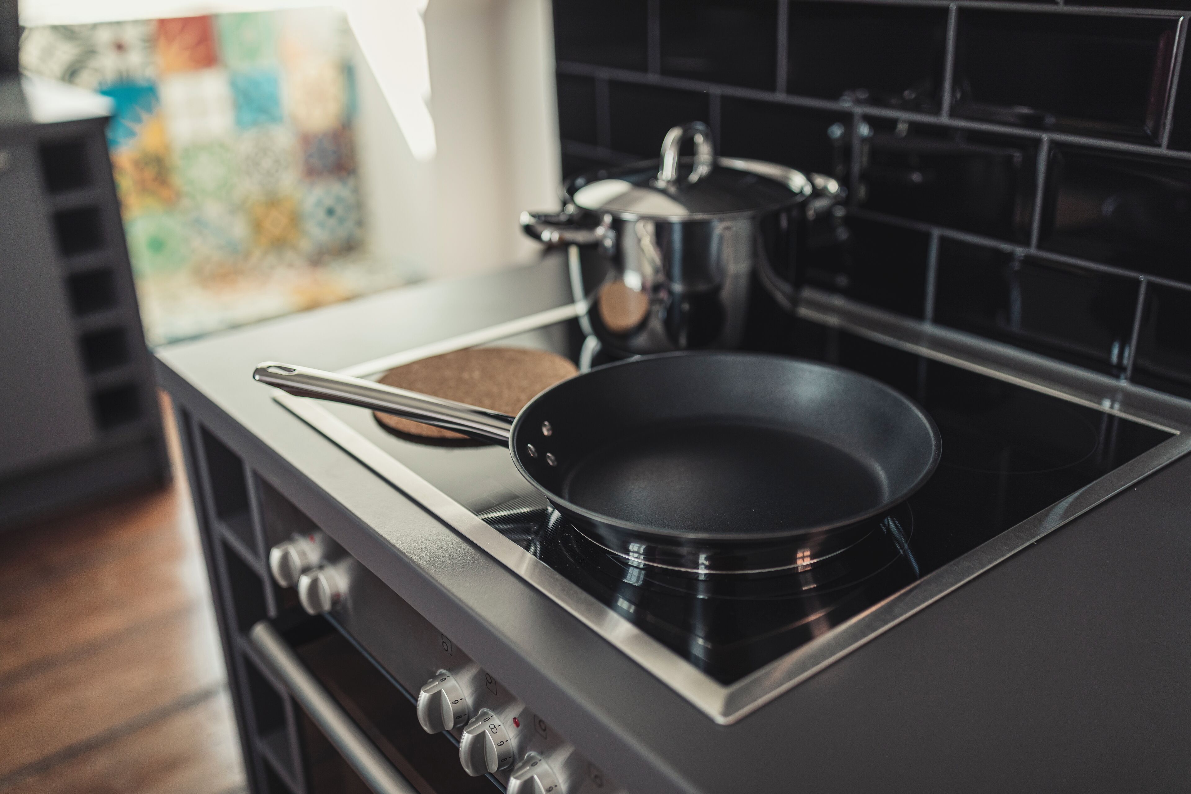 A kitchen with a stove, a frying pan, and a pot.