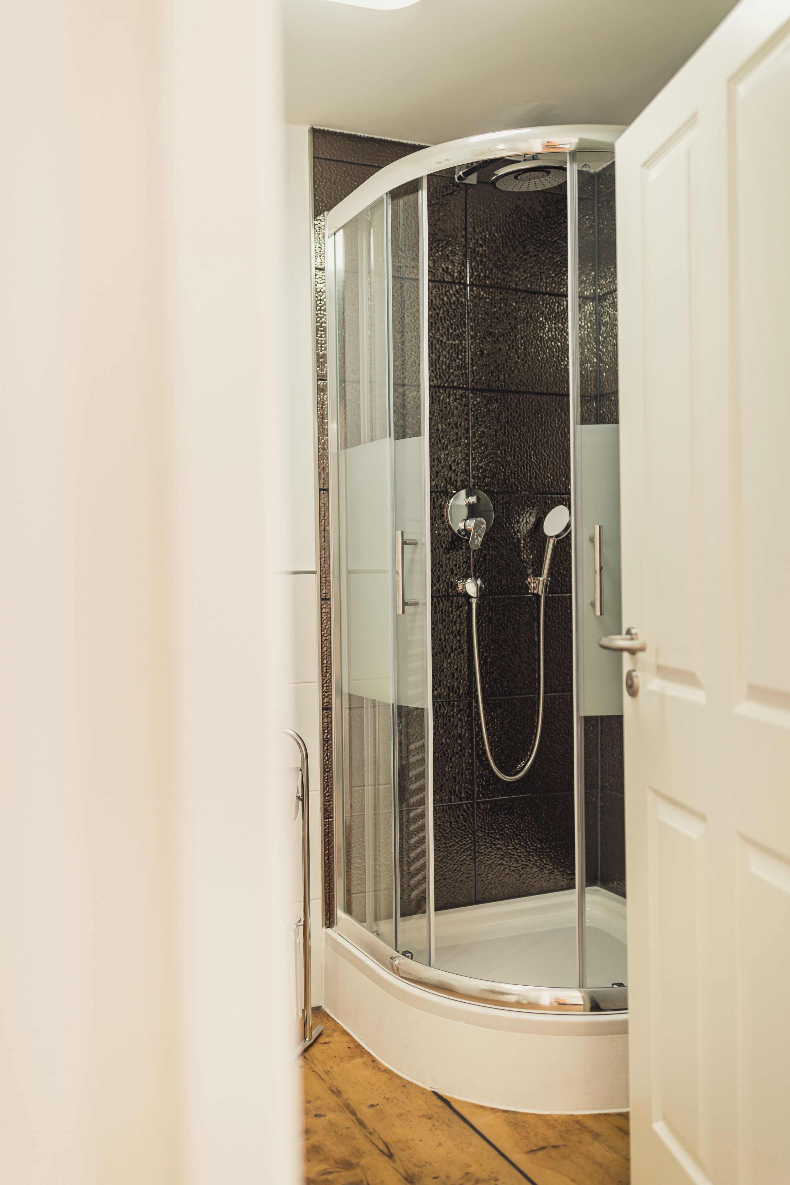 Eine Duschkabine mit Glastüren, eine Badewanne und ein Duschkopf.