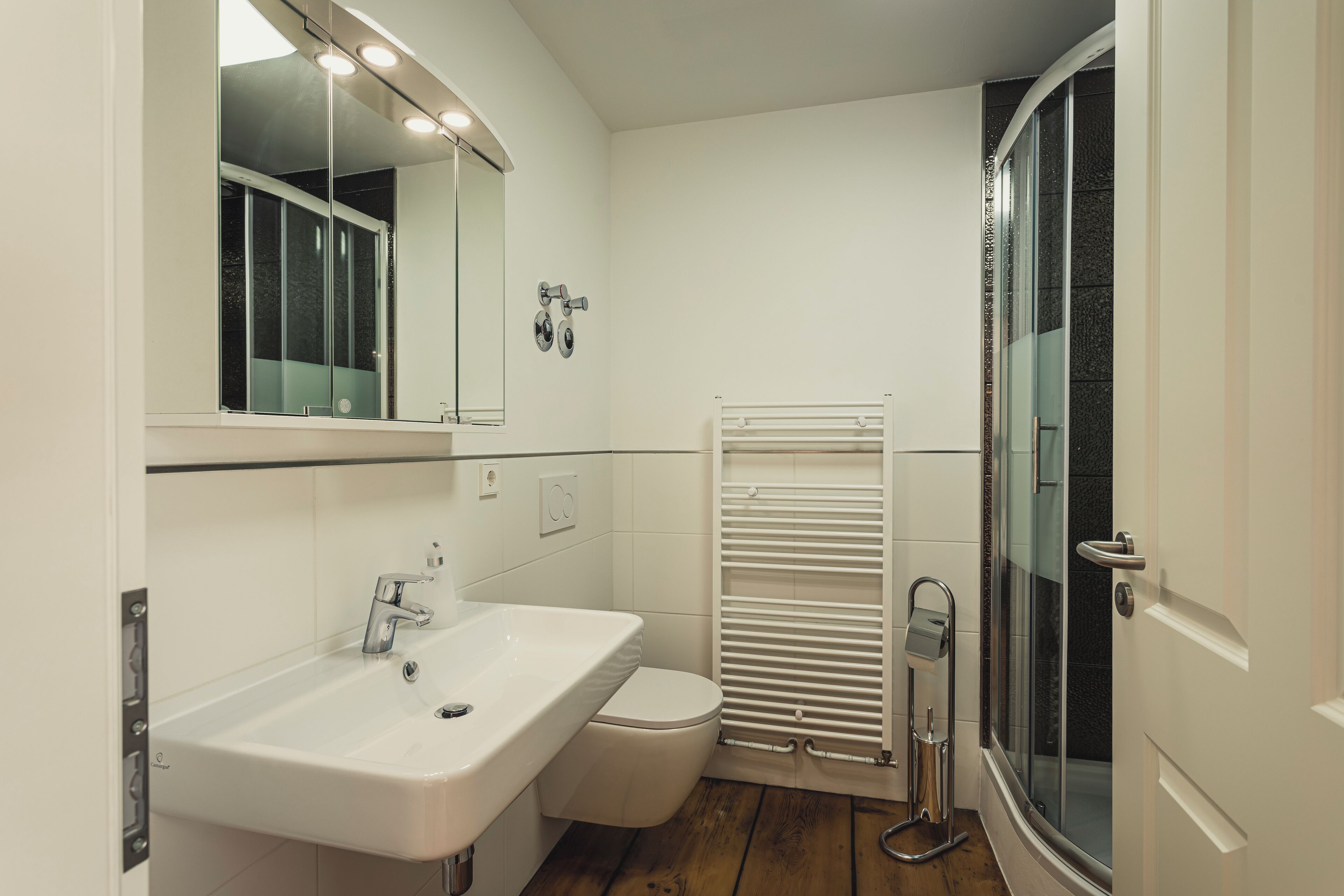 Ein Badezimmer mit Waschbecken, Spiegel und Toilette.