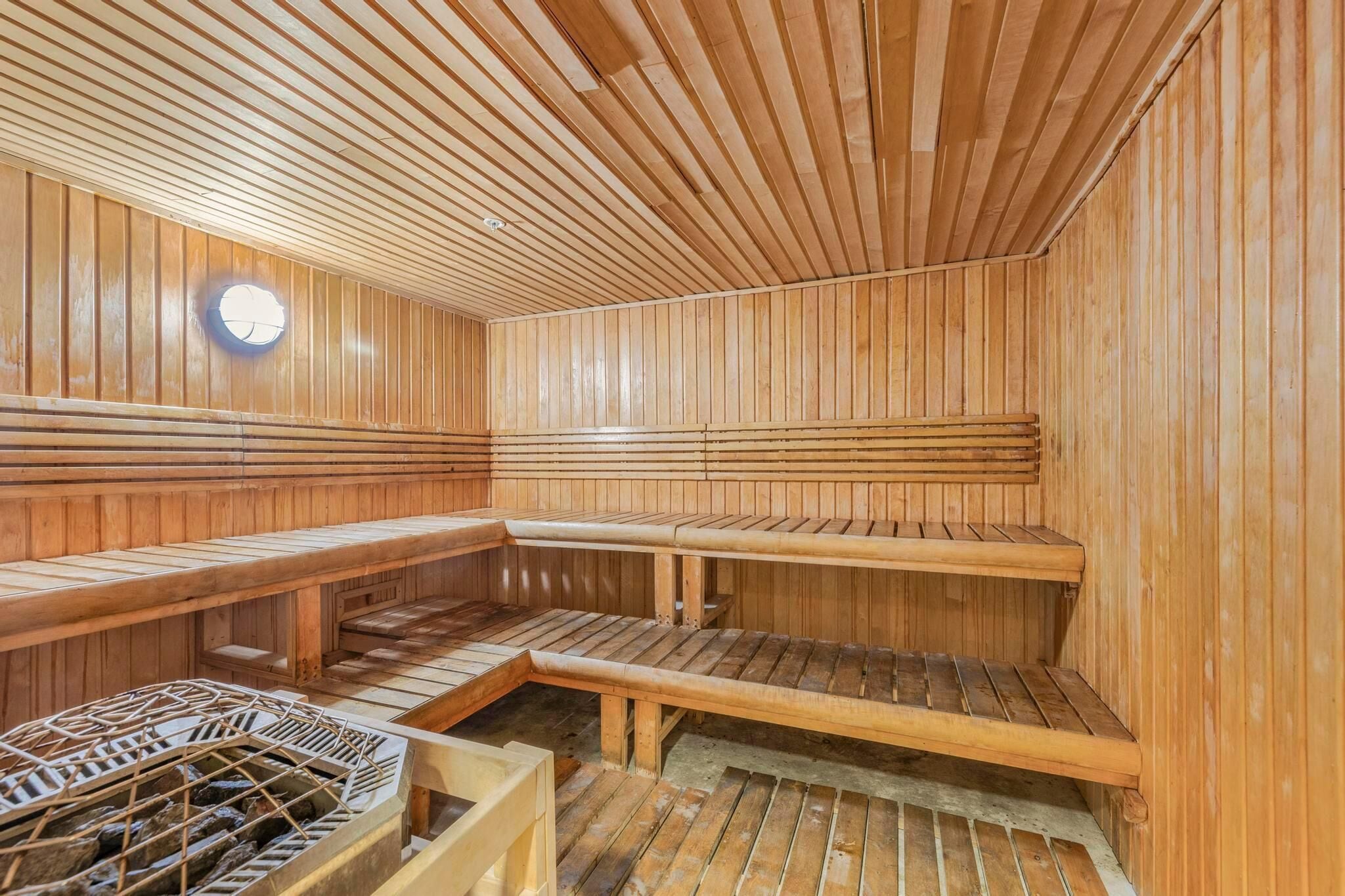 Sauna, jossa on puiset lauteet ja kivikiuas.