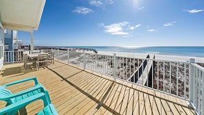 A wooden deck with a white railing overlooking a beach. - Far Reach II (Gulf Shores)