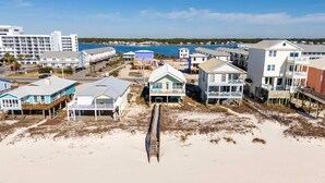 A beachfront property with multiple buildings, including a large white hotel and several smaller houses. - Far Reach II (Gulf Shores)