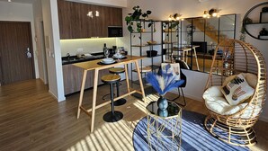 A modern apartment with a kitchen, dining area, and a loft bedroom. - Marinha Grande Apartamentos Duo N°7 (Marinha Grande)