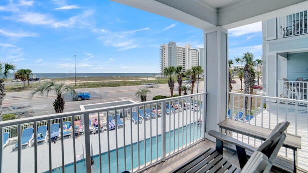 A balcony with a pool, overlooking a beach and a parking area. - Grand Caribbean 209 (Orange Beach)