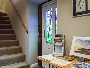 A staircase, a door with stained glass, a desk with books and a framed picture, and a 'No Smoking' sign.