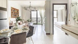 Una camera d'albergo moderna con zona pranzo, un balcone e un grande specchio.