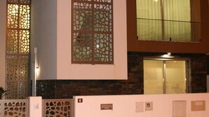 A modern building with a decorative screen, a large window with curtains, and a stone facade. - Silvercoast Villa Concha Baia - private heated pool and rooftop seaview lounge. (Salir do Porto)