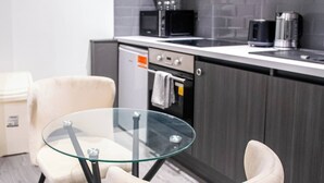 Una cocina moderna con una mesa de vidrio y dos sillas acolchadas.