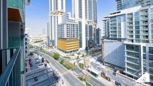 Un complejo de edificios de gran altura con varias torres residenciales, un patio central y una calle concurrida abajo.