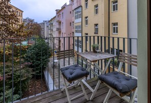 Enjoy a peaceful moment on this balcony overlooking a lush garden.