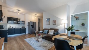 A modern apartment with a kitchen, living room, and dining area. - Peaceful & Cozy Living in Vyšehrad with a Balcony by EasyBNB Premium (Prague)
