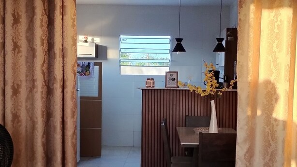 Un comedor con una mesa y sillas de madera, una recepción y una ventana con vistas.