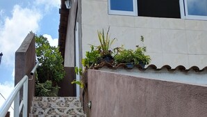 Una escalera con mosaicos que conduce a un edificio de fachada blanca y una ventana.