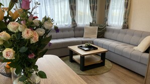A living room with a sofa, a coffee table, and a vase of flowers. - RBR 1132 - Beach Resort Kamperland (Kamperland)