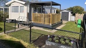 A mobile home with a fenced yard, a small deck, and a garden area. - RBR 1132 - Beach Resort Kamperland (Kamperland)