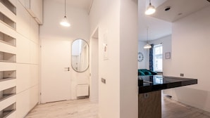 A modern kitchen with a black countertop, white cabinets, and a built-in oven. - Środmieście Apt - Top Location, Tram&Park nearby - by Rentujemy (Wroclaw)