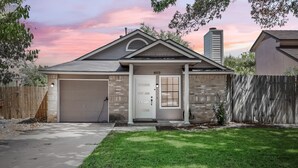 Une maison à deux étages avec un garage, une porte d’entrée et une façade en briques.