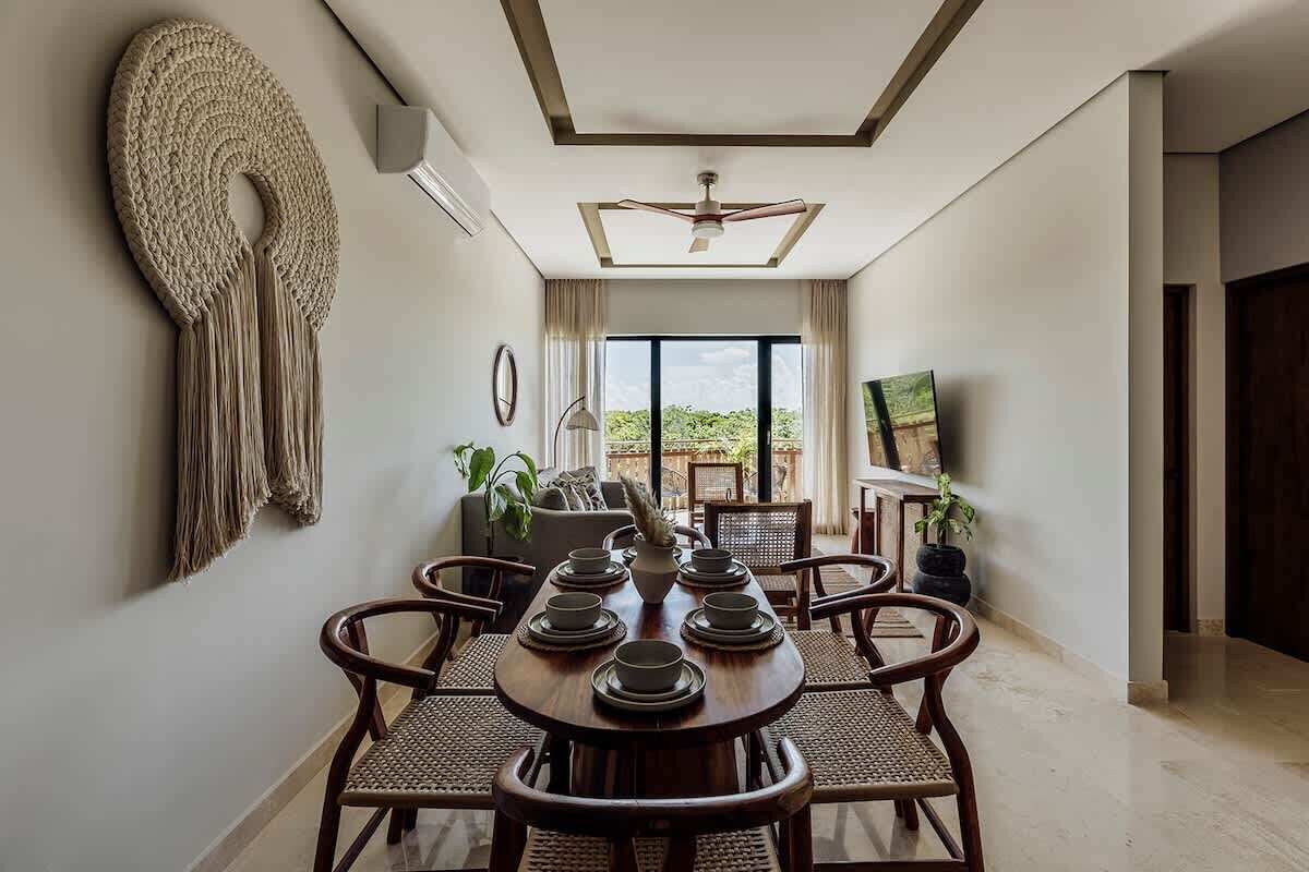 A dining area with a round table, chairs, and a ceiling fan.