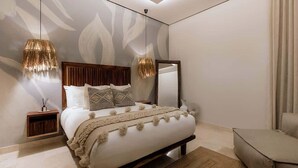 Quarto moderno com uma cama grande, duas luminárias de cabeceira, uma mesa de cabeceira e um espelho.