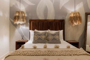 A bed with a wooden headboard, two matching pillows, a fluffy beige throw, and two hanging lamps. - The Mara 2 Bedroom Amira Beach Club Access! (Tulum)