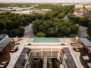 Et resort med swimmingpool, liggestole og udsigt over det omkringliggende grønne område.