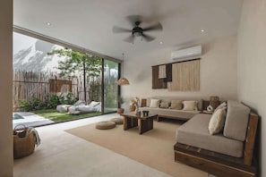 Una sala de estar moderna con sofá, mesa de centro y ventilador de techo.