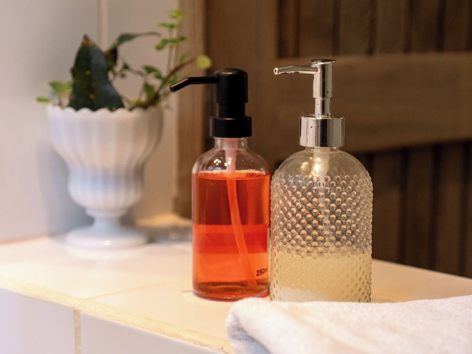 Ein Badezimmer-Waschtisch mit Seifenspender und einer Flüssigseifenflasche.