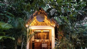 A thatched-roof structure labeled 'Boatik' with a wooden deck leading to the entrance. - Boatique Hotel and Marina (Livingston)