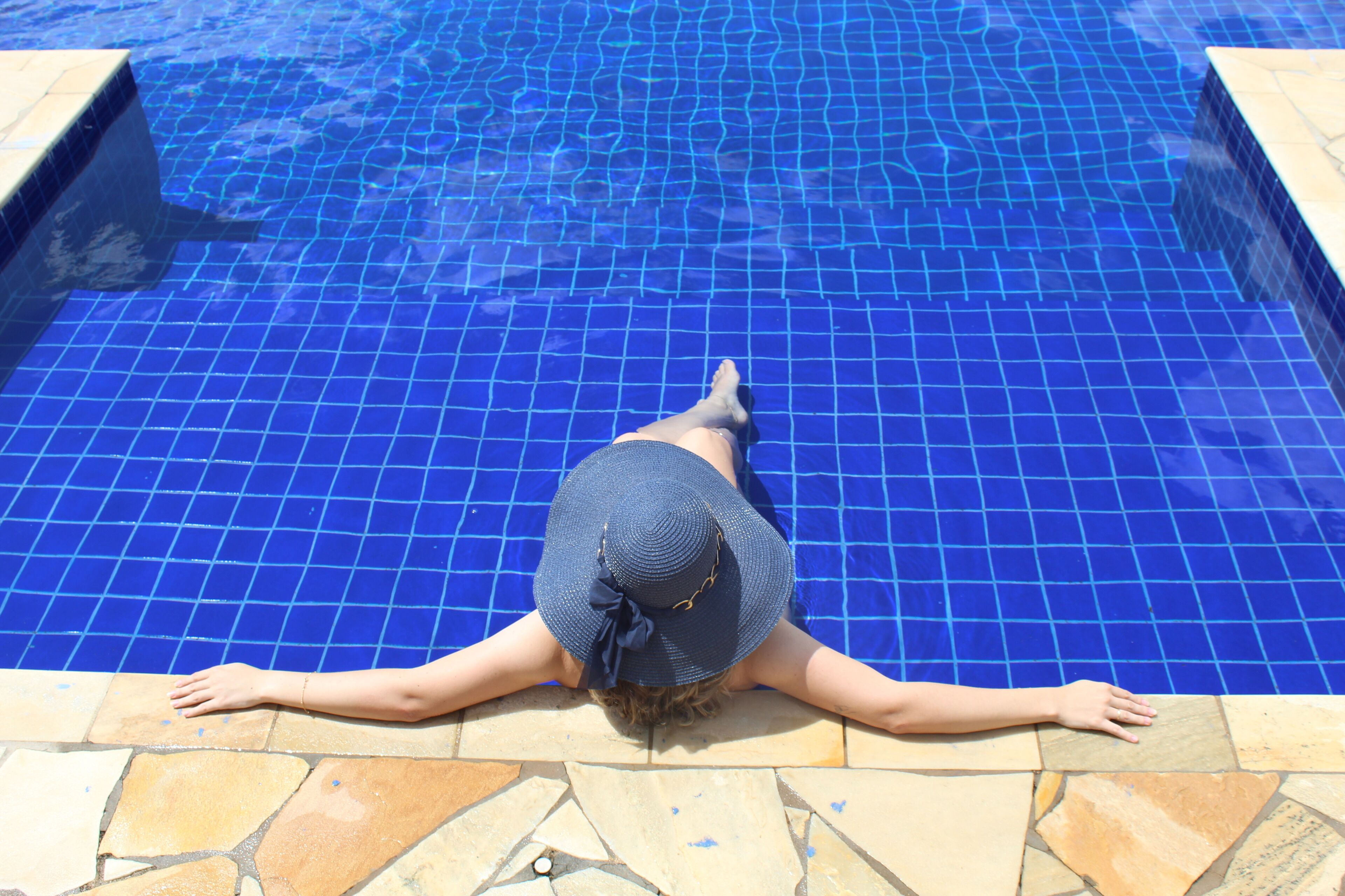 Una piscina al aire libre, sombrillas, sillones reclinables de piscina