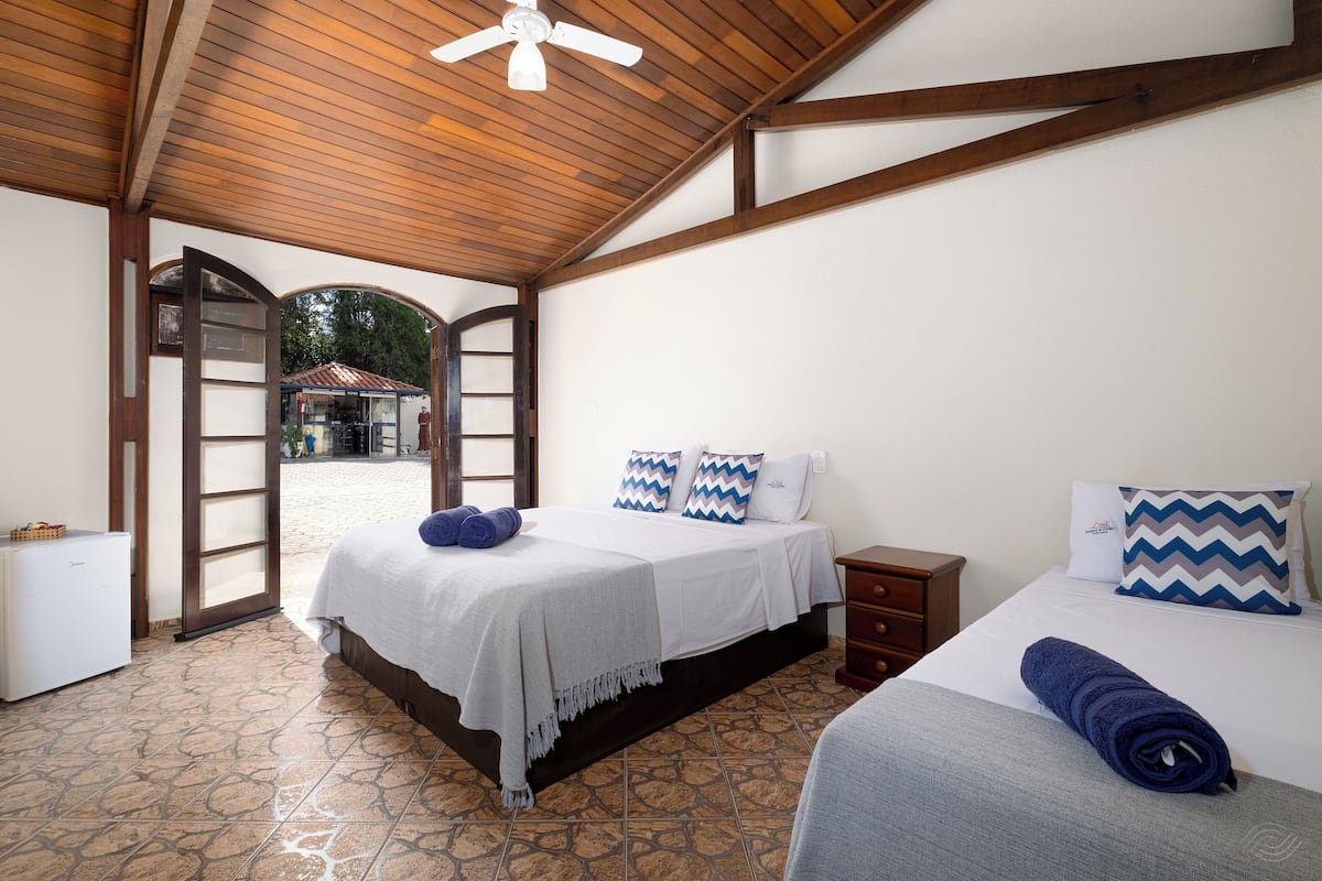 Ein Schlafzimmer mit Bett, Schminktisch, Nachttisch und Deckenventilator.