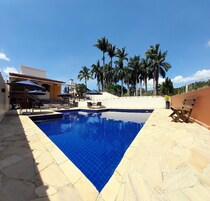 Una piscina al aire libre, sombrillas, sillones reclinables de piscina