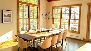 Un comedor con una gran mesa de madera, seis sillas y un candelabro.