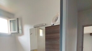 A modern bathroom with a built-in washing machine, a sink with a mirror, and a wooden vanity.