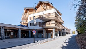 Un edificio a più piani con balconi, un cartello che indica divieto di sosta e un cielo sereno.