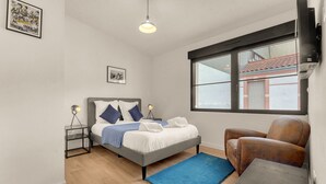 A bedroom with a bed, a chair, a nightstand, a lamp, a window, and a picture on the wall. - Costa Del Sol - Charmant appt pour 2 avec terrasse (Toulouse)