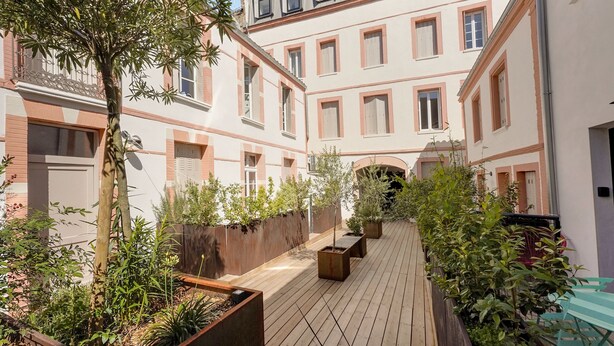 A courtyard with wooden flooring, potted plants, and a tree. - Costa Del Sol - Charmant appt pour 2 avec terrasse (Toulouse)