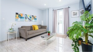 Ein modernes Wohnzimmer mit einer Couch, einem Couchtisch und Kunstwerken an der Wand.