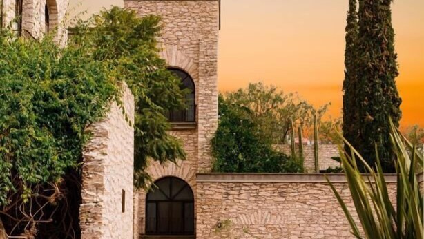 A courtyard with stone walls, a fountain, and potted plants. - Hotel Casa Mexicana (Mineral de Pozos)
