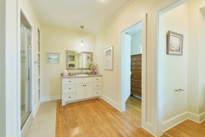A bathroom with a vanity, mirror, and wooden flooring. - BEE Inn BRENHAM Holiday Cottage - Premium location walking distance to downtown. (Brenham)