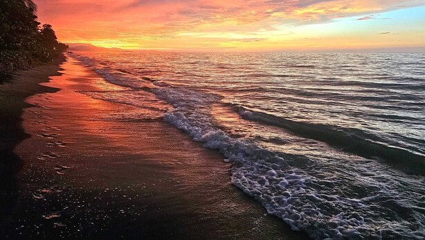 A beach with waves at sunset. - Charming 2-bedroom house with WiFi, AC in Dibulla, ocean view. (Dibulla)