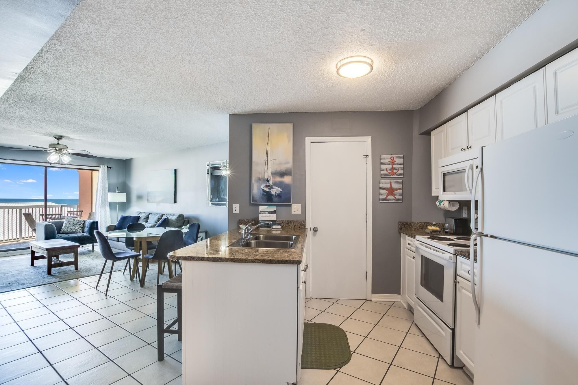 A compact kitchen with white cabinets and a built-in microwave.